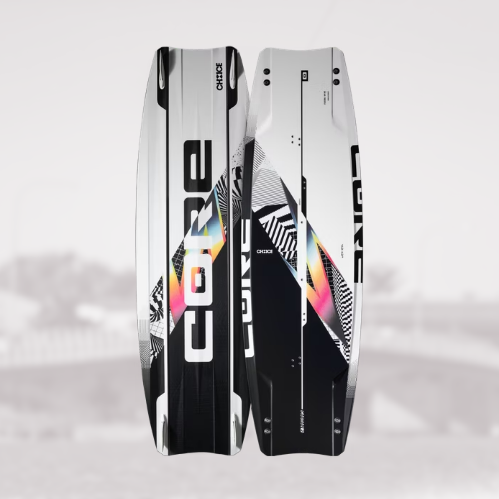 Two kiteboards shown upright against a light gray background, displaying both the topsheet and the bottomsheet views. The boards feature a white, black, and gray geometric pattern with a prominent holographic rainbow graphic running diagonally.